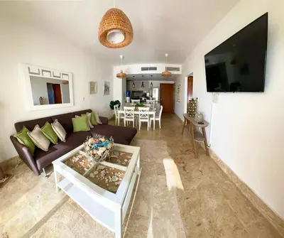 a living room with a couch and a tv at Residencial la ensenada, on Playa Nueva Romana