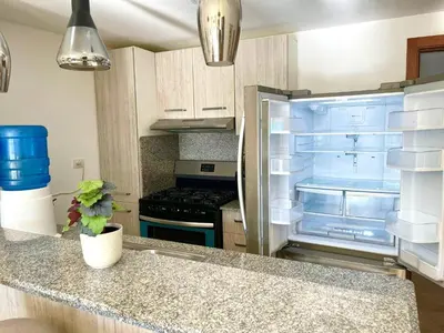 a kitchen with a refrigerator with its door open at Residencial la ensenada, on Playa Nueva Romana