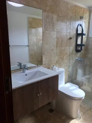 a bathroom with a sink and a toilet and a mirror at Residencial la ensenada, on Playa Nueva Romana