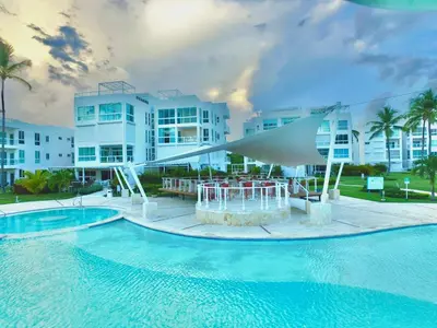 a swimming pool with a fountain in front of a building at Residencial la ensenada, on Playa Nueva Romana