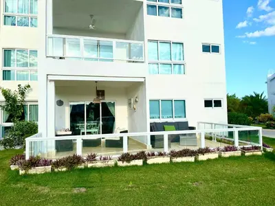 a large white building with a balcony in front of it at Residencial la ensenada, on Playa Nueva Romana