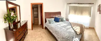 a bedroom with a bed and a dresser and a mirror at Residencial la ensenada, on Playa Nueva Romana