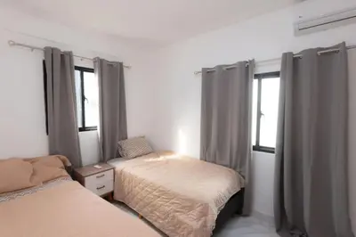 a bedroom with two beds and two windows at Luxury Villa with Private Pool in Punta Cana in Punta Cana