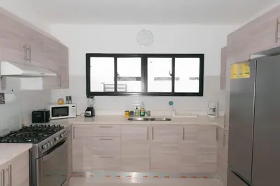 a white kitchen with a sink and a window at Luxury Villa with Private Pool in Punta Cana in Punta Cana