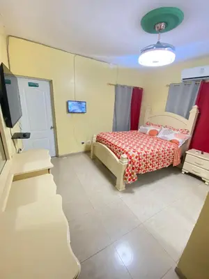 a bedroom with a bed and a tv in it at Alojamiento en Bani, cerca de la playa y las Dunas in Colorado