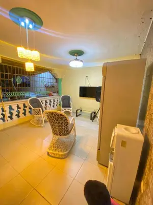 a living room with chairs and a refrigerator at Alojamiento en Bani, cerca de la playa y las Dunas in Colorado