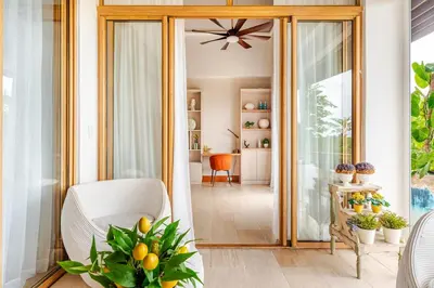 a living room with a white chair and a mirror at Casa Cielo 3 BR Penthouse with Views in La Romana