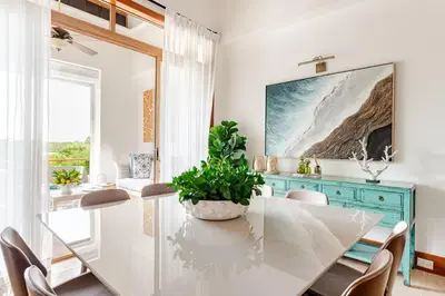 a dining room with a white table and a blue cabinet at Casa Cielo 3 BR Penthouse with Views in La Romana