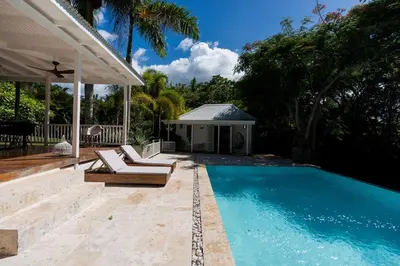 a swimming pool with two lounge chairs next to a house at Modern villa with private pool 1 km from the beach samana in El Limón