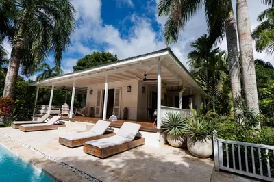 a patio with lounge chairs and a house with a pool at Modern villa with private pool 1 km from the beach samana in El Limón