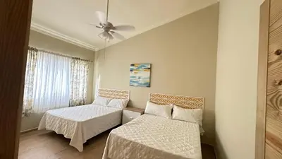 a bedroom with two beds and a ceiling fan at Villa Enma RD in Nizao
