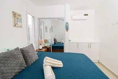 a bedroom with a blue bed and a mirror at Modern 2BR Condo with Pool 10min walk to Beach - Caribbean Rose in San Rafael del Yuma