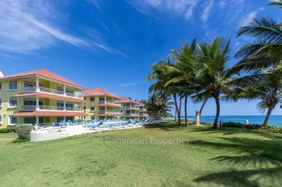 a resort with palm trees and chairs and the ocean at Ocean front, direct access to the beach in Cabarete