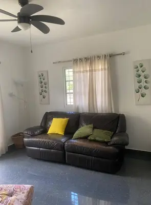 a living room with a brown leather couch with yellow pillows at Villa Rancho losindios