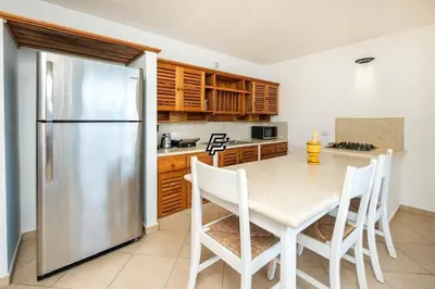 a kitchen with a table and a stainless steel refrigerator at Luxury Penthouse in front of the Sea in Las Terrenas in Las Terrenas