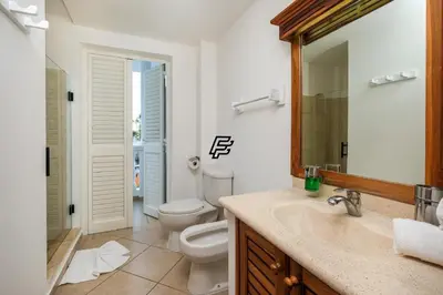 a bathroom with a toilet and a sink and a mirror at Luxury Penthouse in front of the Sea in Las Terrenas in Las Terrenas