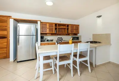 a kitchen with a table and chairs and a refrigerator at Luxury Penthouse in front of the Sea in Las Terrenas in Las Terrenas