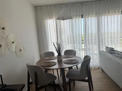 a dining room table and chairs in a room at Cozy Apt Steps from Los Corales Beach in Punta Cana