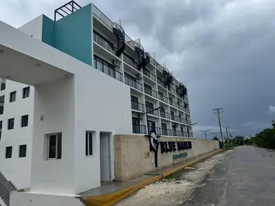 a white building with a sign on the side of it at Cozy Apt Steps from Los Corales Beach in Punta Cana
