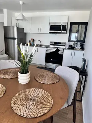 a kitchen with a wooden table and a dining room at Cozy Apt Steps from Los Corales Beach in Punta Cana