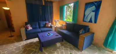 a living room with two blue couches and a table at Studio surrounded by nature in Cabarete