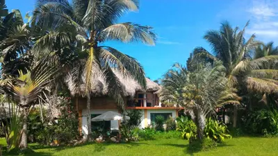 a house with palm trees in front of it at Studio surrounded by nature in Cabarete
