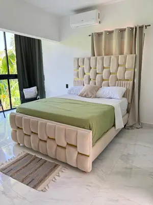 a large bed with a large padded headboard in a bedroom at Nashaly suite in Arroyo El Cabo