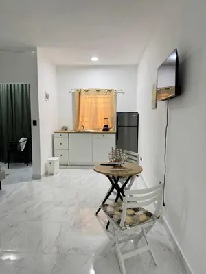 a living room with a table and a kitchen at Nashaly suite in Arroyo El Cabo