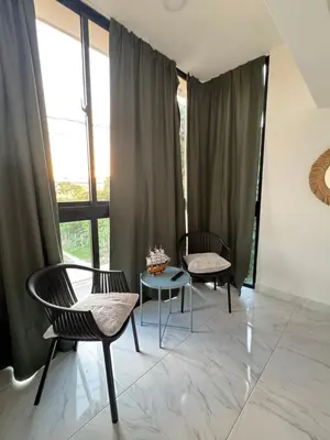 two chairs and a table in a room with windows at Nashaly suite in Arroyo El Cabo
