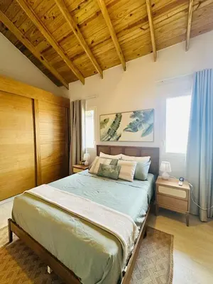 a bedroom with a large bed with a wooden ceiling at IBE 402 Penthouse with Pool Garden Breeze Dominicus in La Laguna