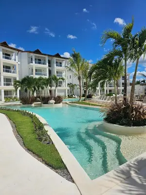 a swimming pool with palm trees and buildings at IBE 402 Penthouse with Pool Garden Breeze Dominicus in La Laguna
