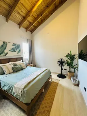 a bedroom with a bed and a fan in it at IBE 402 Penthouse with Pool Garden Breeze Dominicus in La Laguna