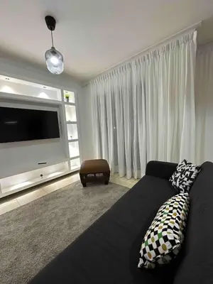 a living room with a couch and a flat screen tv at Burungos Place at Terrazas del Caribe in Ensanche Savica de Mendoza