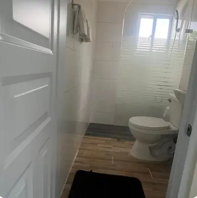 a white bathroom with a toilet and a window at Apartamento Luna Llena in Colorado