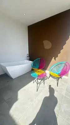 a shadow of a person taking a picture of two chairs and a tub at Estancia Rincon del AMOR in Juan López