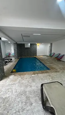 a large swimming pool in a room with chairs at Estancia Rincon del AMOR in Juan López
