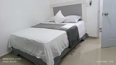 a bed with white sheets and pillows in a room at Remanso de Paz in Pedernales