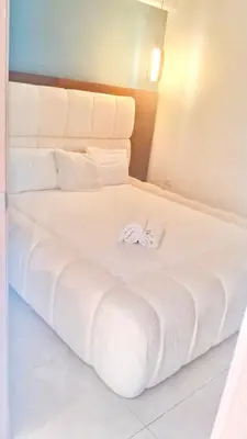 a white bed with two towels on top of it at Ocean Views Escape at DGM Resort in Boca Chica