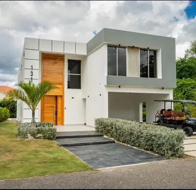 a white house with a tree in front of it at New villa with 4 bedrooms and 5 beds in La Romana