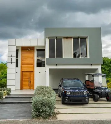 a house with a golf cart parked in front of it at New villa with 4 bedrooms and 5 beds in La Romana