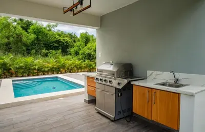 a kitchen with a stove and a swimming pool at New villa with 4 bedrooms and 5 beds in La Romana
