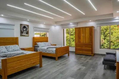 a bedroom with two beds and two windows at Great villa with pool table in La Romana