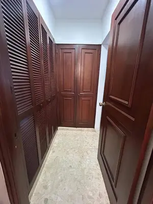 a hallway with two wooden doors and a tile floor at Cozy apartment in Piantini city center in Santo Domingo