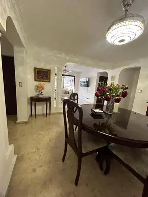 a dining room with a table with flowers on it at Cozy apartment in Piantini city center in Santo Domingo