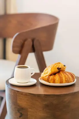 a plate of bread and a cup of coffee on a table at Hydra 103 Poolview Luxury Apt Dominicus in La Laguna