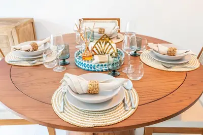 a wooden table with plates and dishes on it at Hydra 103 Poolview Luxury Apt Dominicus in La Laguna