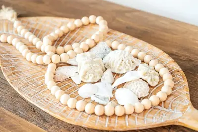 a wooden plate with shells on a wooden table at Hydra 103 Poolview Luxury Apt Dominicus in La Laguna