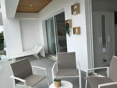 a balcony with two chairs and a table at Boca Beach Residence 304 in Boca Chica
