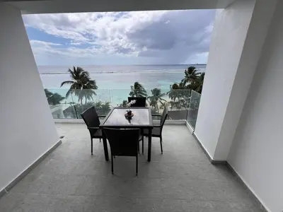 a table and chairs on a balcony with a view of the ocean at Boca Beach 504, Boca Chica in Boca Chica