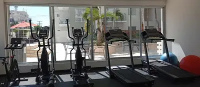 a row of treadmills in a gym with a window at Boca del Mar Tower III Apart 401 in Boca Chica